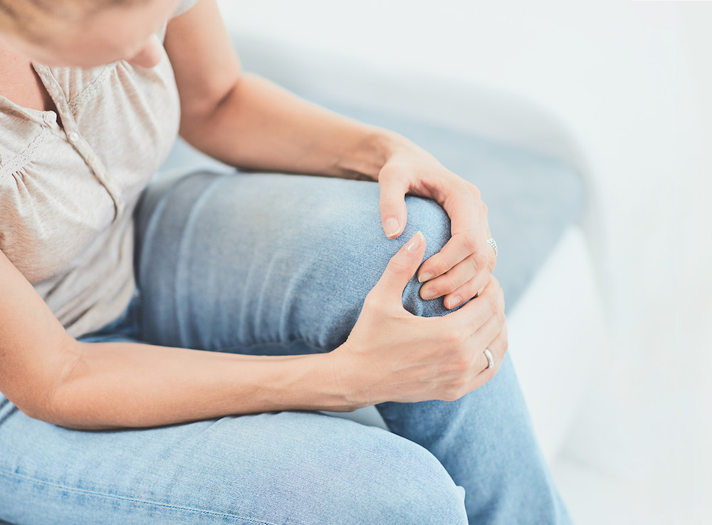 A woman holding her injured knee